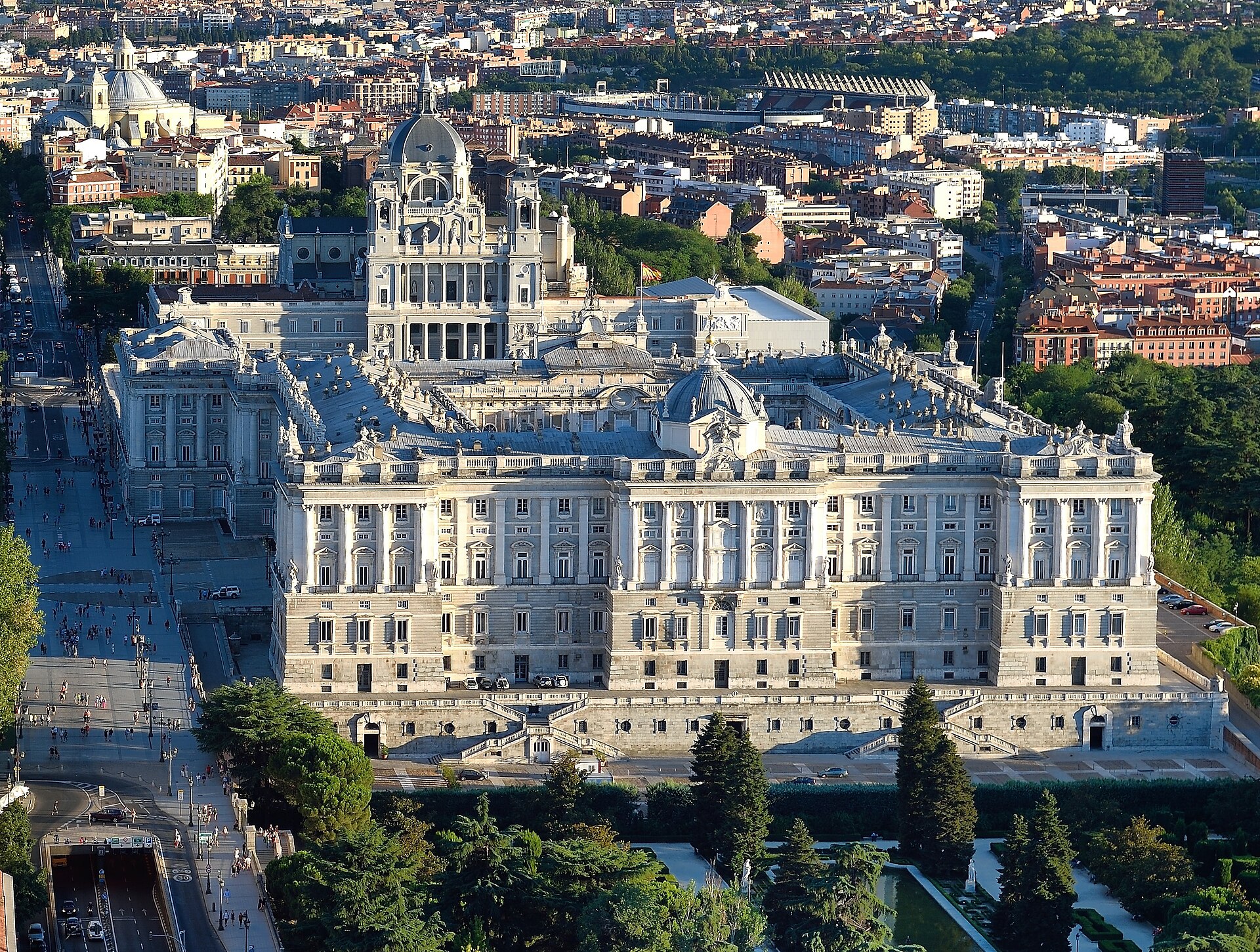 Palacio Real de Madrid visto desde el aire, con la catedral de la Almudena detrás y jardines delante.